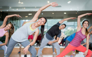 Gemengde groep jonge mensen stretchen tijdens aerobics